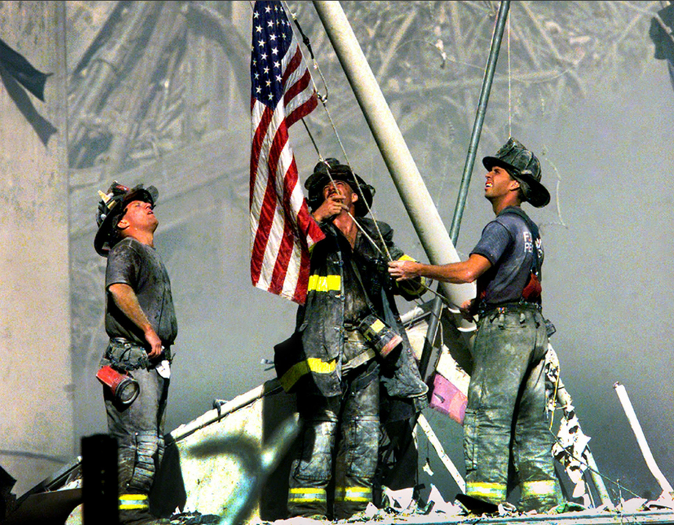 Strażacy stawiają amerykańską flagę na ruinach World Trade Center. (2001)