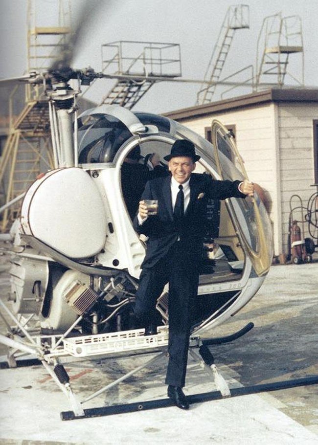 Frank Sinatra wysiada z helikoptera, trzymając drinka