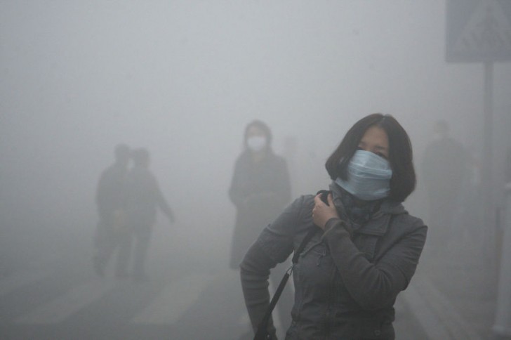 Dziewczyna idąca przez smog w Pekinie, gdzie zanieczyszczenie powietrza przekracza normę bezpieczeństwa czterdziestokrotnie.