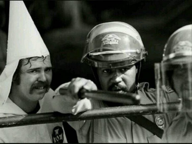 Czarnoskóry policjant chroni członka Ku Klux Klanu podczas manifestacji.