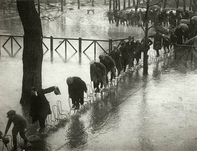 Grupa ludzi próbuje przejść przez wodę podczas wielkiej powodzi, Paryż 1924.