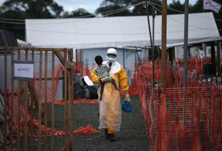 a-doctors-without-borders-health-worker-in-protective-clothing-carries-a-child-suspected-of-having-ebola-in-the-groups-treatment-center-on-oct-5-in-liberia