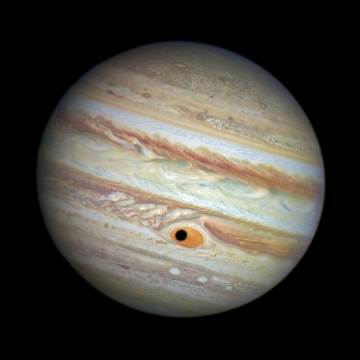 on-april-21-the-hubble-telescope-captured-what-looks-like-a-black-hole-in-jupiters-great-red-spot--but-really-its-the-shadow-of-the-jovian-moon-ganymede