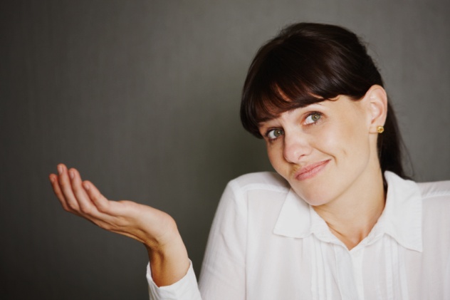 Portrait of woman shrugging and looking at the camera with copyspace