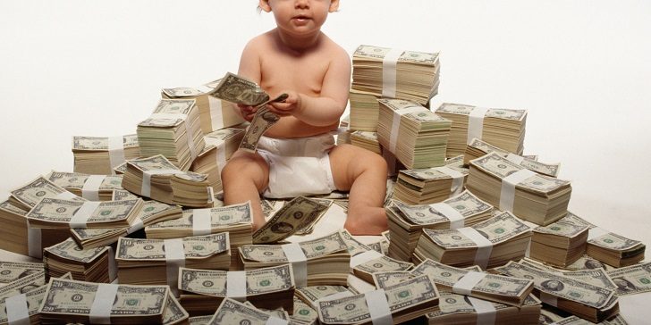 Toddler sitting on stacks of money