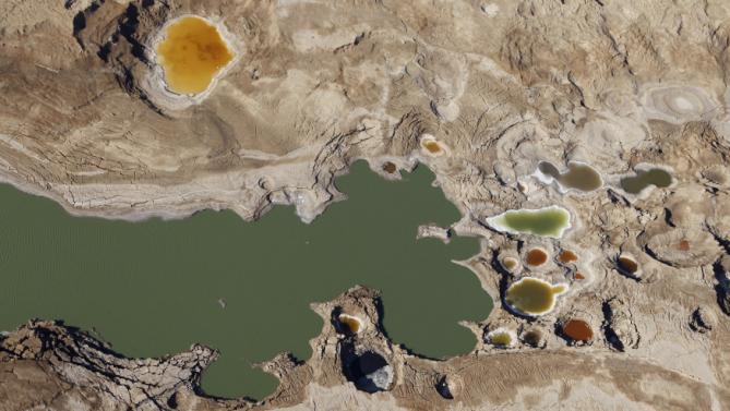 Sink holes filled with water are seen in this aerial view of the Dead Sea December 5, 2011. (REUTERS/Baz Ratner)