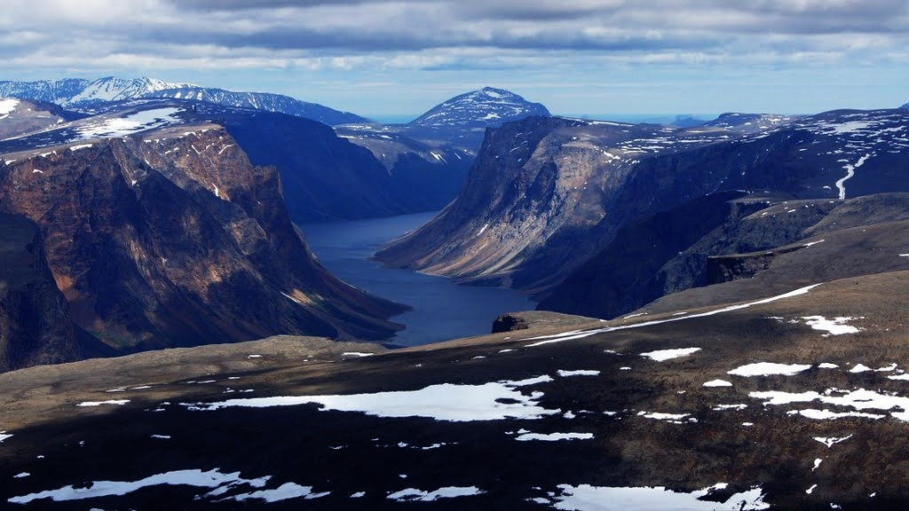 Na zdjęciu widoczny Saglek Fjord - olbrzymi nadmorski klif znajdujący się na jednej z wysp północno-wschodniej Kanady. Skalisty teren pokrywa jedynie niska roślinność - trawy, mchy, porosty.